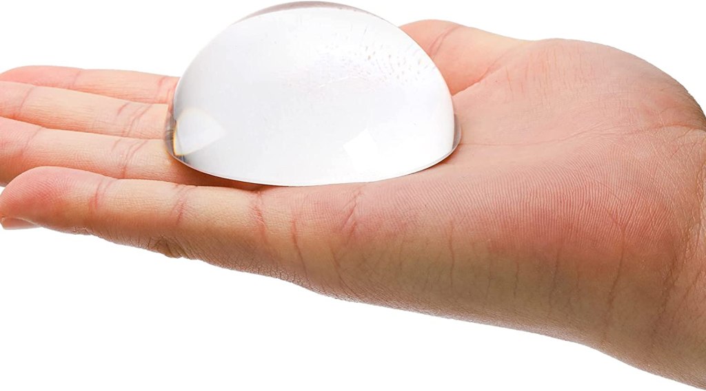 clear glass paperweight in the palm of someone's hand