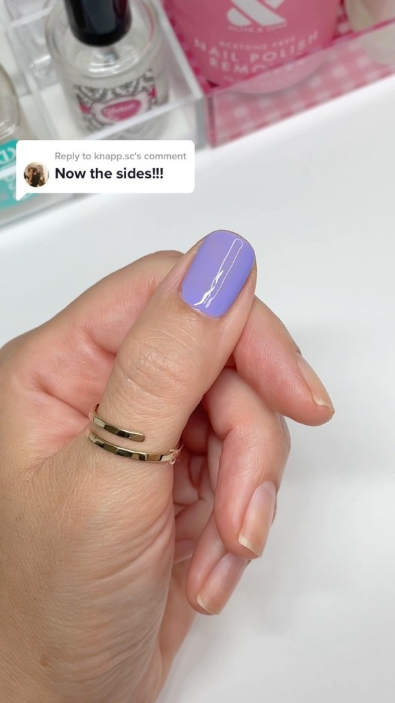 A woman's hand and finger nails wearing Color Club purple nail polish in Lily in Paris