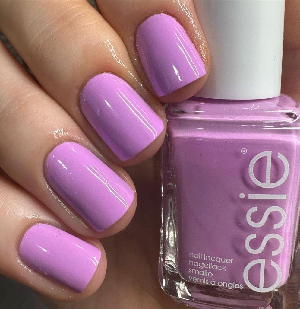 A woman's hand and finger nails wearing Essie lavender nail polish in the you-niverse, summer 2023 nail trends