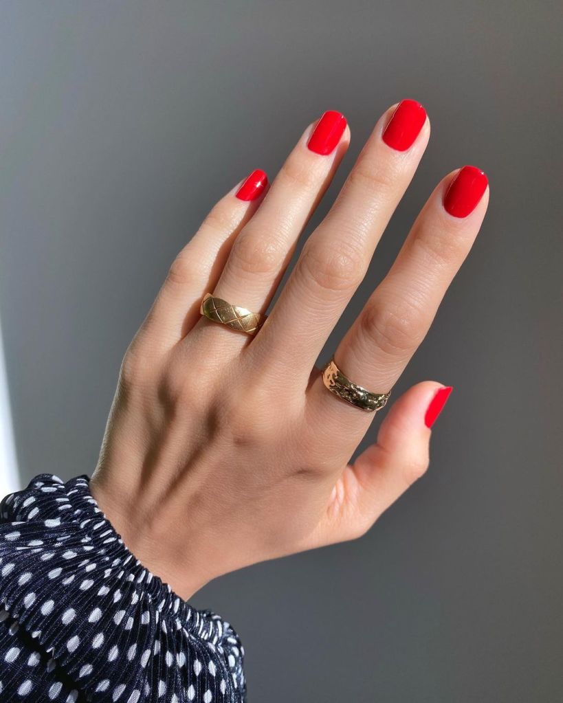 A woman's hand and finger nails with Chanel red nail polish