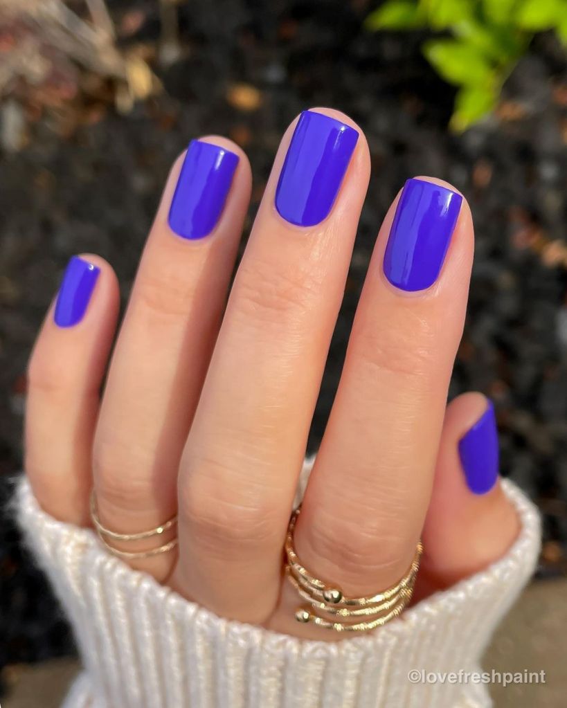 A woman's hand and finger nails wearing Mooncat electric blue nail polish in Blue Tango, summer 2023 nail trends