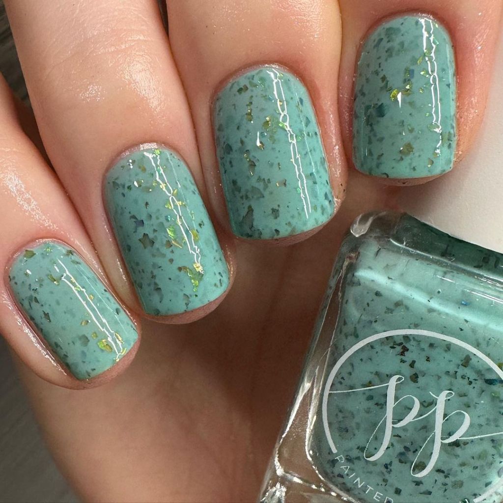 A woman's hand and finger nails wearing Painted Polish green, sparkly nail polish, Minty meadows