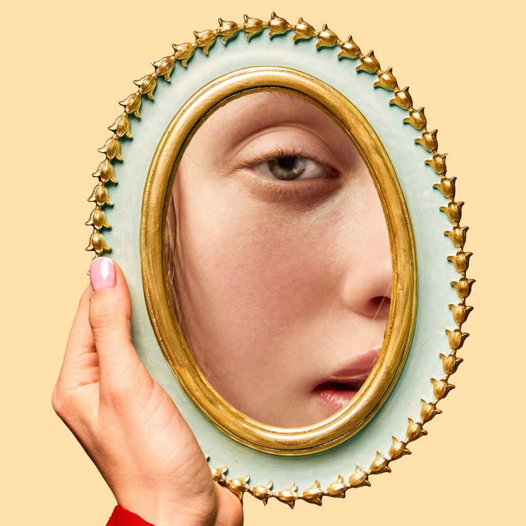 atomic habits: woman looking at herself in the mirror