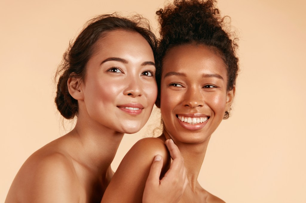 skincare: Beauty. Smiling women with perfect face skin and natural makeup portrait. Beautiful happy asian and african girl models with different types of skin on beige background. Spa skin care concept
